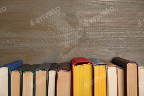 Preview: Stack of hardcover books on wooden background. Space for text