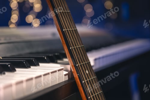 Preview: Guitar and piano keys close-up on a blurred background with bokeh.