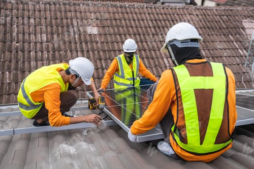 Preview: Service engineer installing solar cell on the roof of house. Technicians working about solar panel.