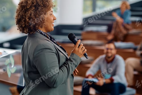 Preview: Happy female speaker talking on a business conference at convention center.