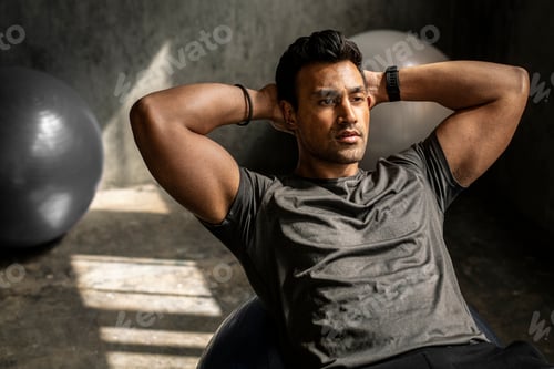 Preview: Sportive man doing the sit-ups on a balance ball