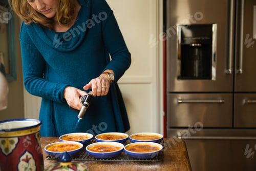 Preview: Woman making crême brûlée in the kitchen