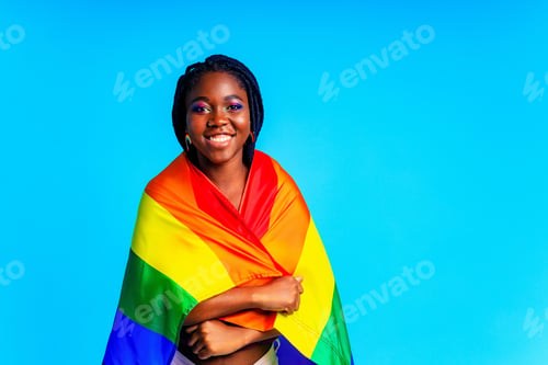 Preview: brazilian woman in multi color top blouse rainbow and make up in blue studio background