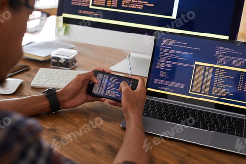 Preview: Software Developer Holding Smartphone at Workplace Close Up