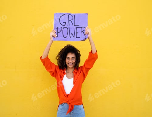 Preview: Cheerful smiling african american girl holding a sign that says girl power