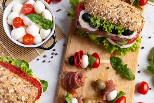 Preview: Delicious Caprese Sandwiches and Skewers on Wooden Board