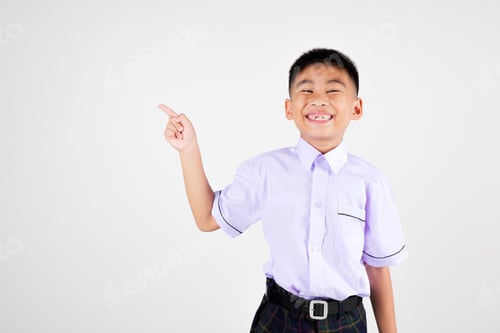 Preview: Portrait smile Asian little boy primary posing point finger to side away studio isolated white