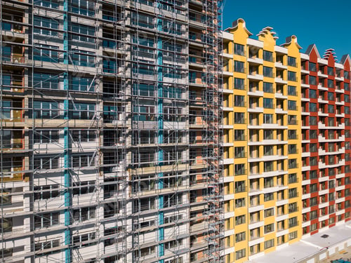 Preview: Drone flight along the facade of a modern apartment building under construction surrounded by