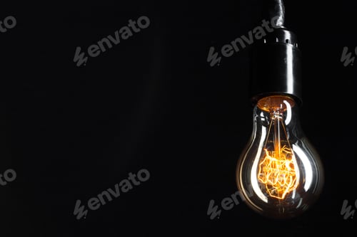 Preview: A classic Edison light bulb on dark background with space for text