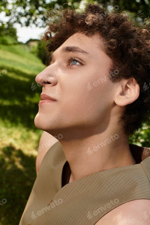 Preview: Young man enjoys summer in green park showcasing stylish seasonal fashion