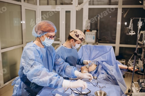 Preview: Confident surgeon wearing protective mask looking at the patient and feeling concentrated during