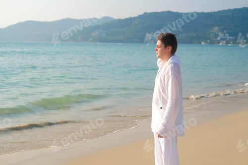 Preview: A Man In White Clothing Holds His Hands In A Namaste Gesture And Practices Yoga Meditation.