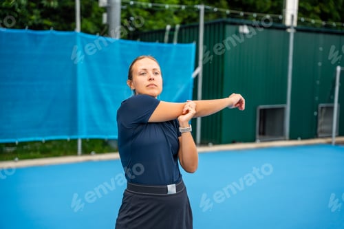 Preview: Professional female tennis player warming up before tennis play on outside court