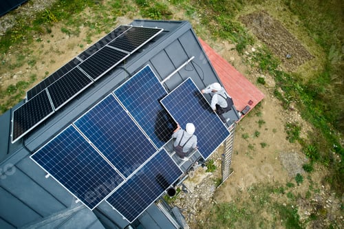 Preview: Technicians carrying photovoltaic solar module while installing solar panel system on roof of house