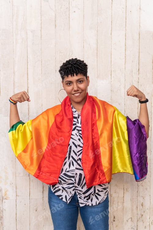 Preview: Young person showing strength with lgbtq+ pride flag