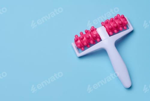 Preview: A plastic body massager on a blue background, top view. Body care.