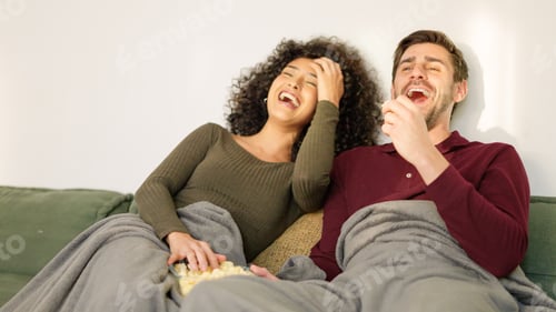 Preview: Couple laughing while watching fun film at home