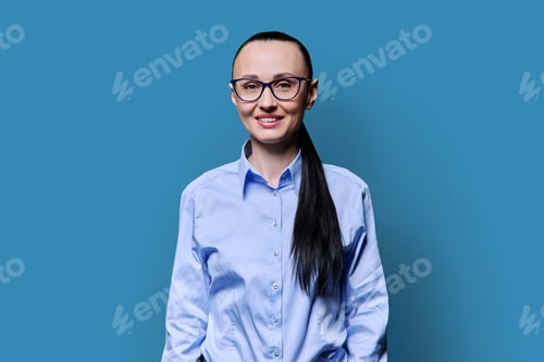 Preview: Portrait of smiling business middle aged woman on blue background