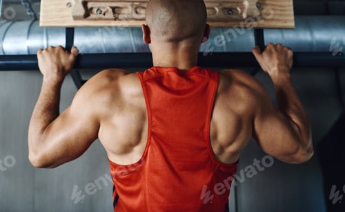 Preview: If it doesnt challenge you, it doesnt change you. Rearview shot of a man doing pull-ups at the gym.
