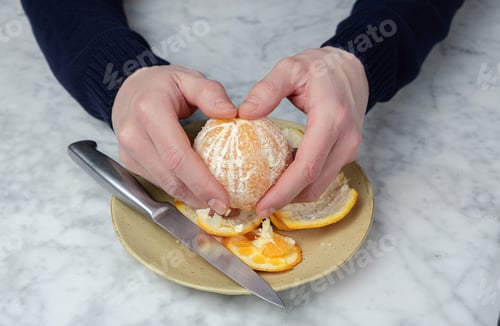 Preview: Man's hands peeling an orange. Healthy food concept