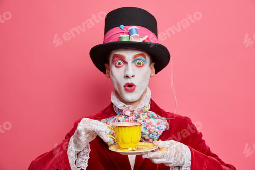 Preview: Photo of shocked emotional mysterious character wears bright halloween makeup drinks tea on party pr