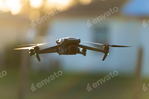 Preview: Drone aircraft with blurred fast rotating propellers and video camera flying in air