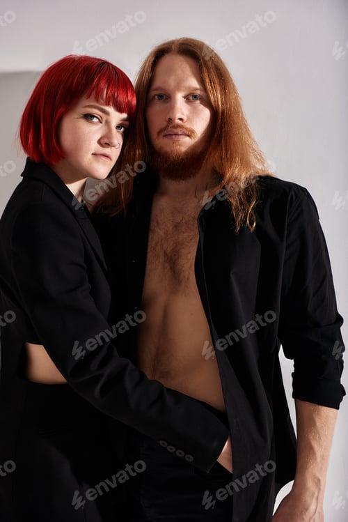 Preview: Studio portrait of a couple in love. A handsome man with long hair and a beard, a charming woman