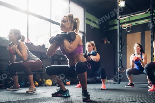 Preview: Women training in gym, squatting with kettle bells