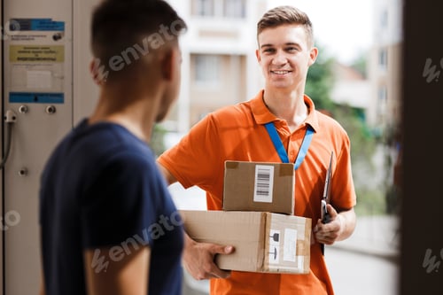 Preview: A smiling person wearing an orange T-shirt and a name tag is delivering parcels to a client