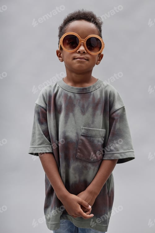 Preview: Portrait of Confident Boy in Sunglasses Posing in Studio on Grey Background