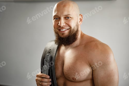 Preview: Strong bodybuilder with muscular chest and shoulders in gym