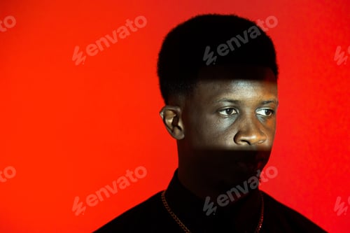 Preview: Black man wearing necklace against red background