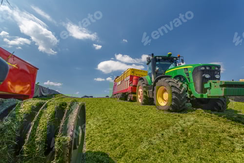 Preview: tractor harvesting hay for animals, tractor harvesting green grass for feed, agribusiness concept