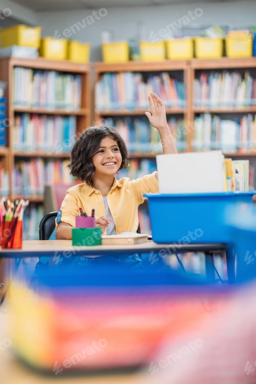 Preview: beautiful little girl raising hand on lesson at library