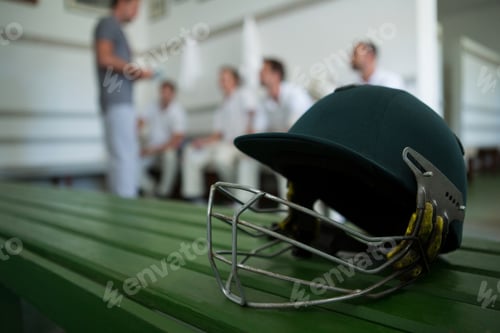 Preview: Close up of cricket helmet on table against team