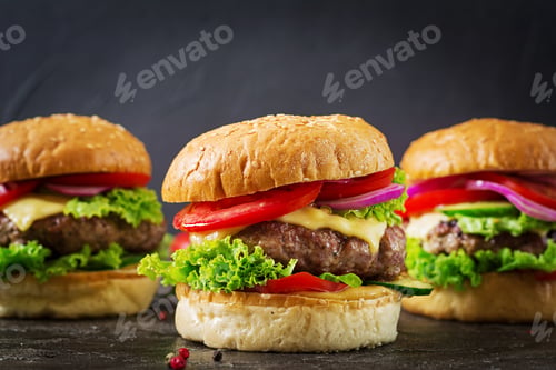 Preview: Three hamburger with beef meat burger and fresh vegetables on dark background. Tasty food.