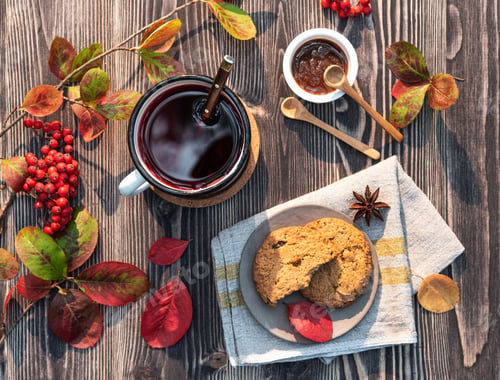 Preview: red cup of tea with cinnamon stick, jam and cookies on wooden table autumn mood