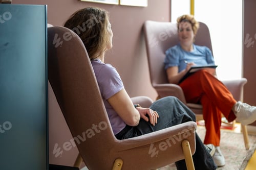 Preview: Two people conversing in a cozy room.