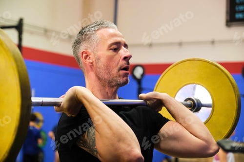 Preview: Man practicing front squats in cross training gym.