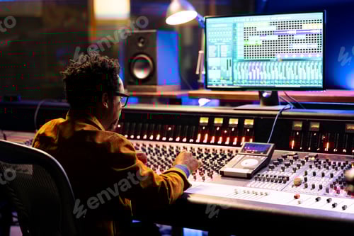 Preview: African american sound designer uses mixing console with knobs and faders