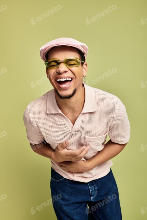 Preview: Trendy young man enjoying a joyful moment in stylish outfit against a vibrant backdrop