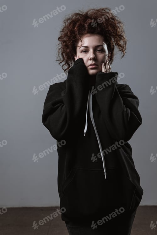 Preview: Portrait Of A Beautiful Curly-Haired Girl With Redheads On A Gray Background