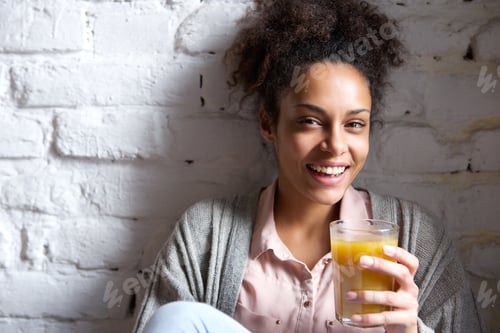 Preview: Beautiful young woman smiling with orange juice