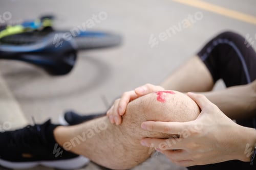 Preview: Man with injured knee sitting near bicycle outdoors, falling down from bicycle. Concept accident fro