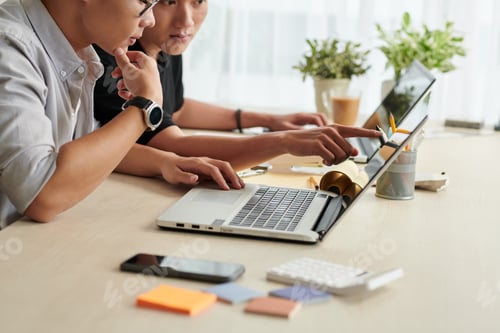 Preview: Men Working Together at a Desk with Laptop
