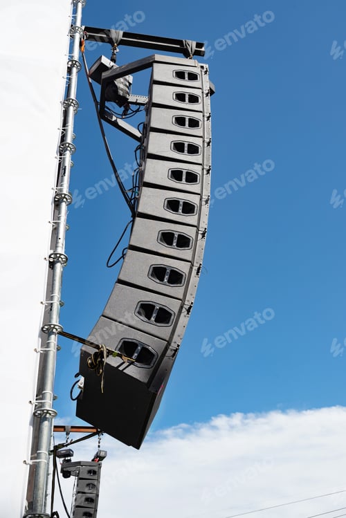 Preview: Stage lighting equipment hanging from trusses at an event venue.
