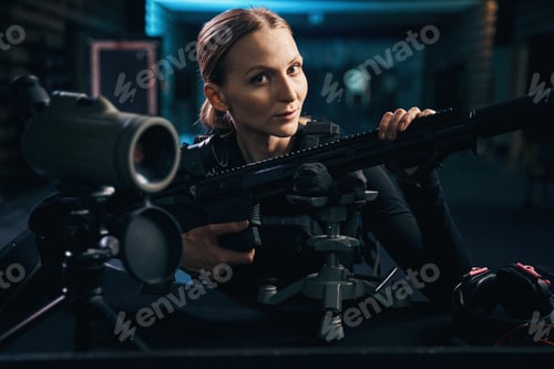 Preview: Calm attractive female sniper posing for the camera indoors