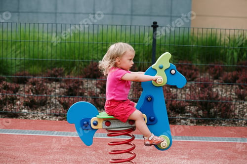 Preview: baby girl on the child playground, horse riding