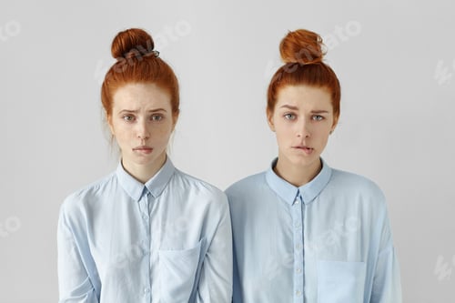 Preview: Human face expressions and emotions. Portrait of two cute redhead student girls wearing same hairsty