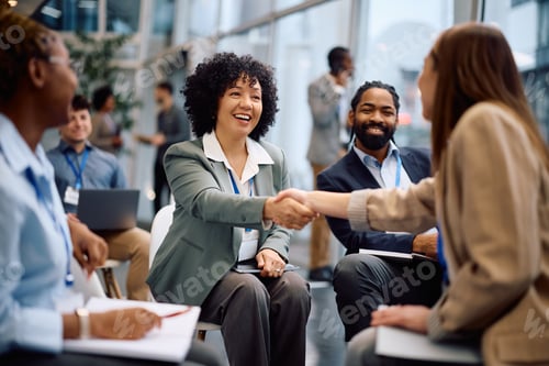 Preview: Happy businesswoman greeting her colleagues on a seminar in board room.